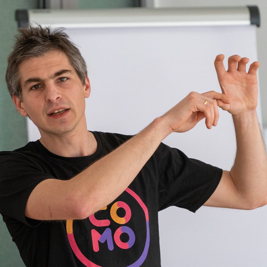 Daniel Sack explaining something with both hands in front of a flipchart at ComoCamp